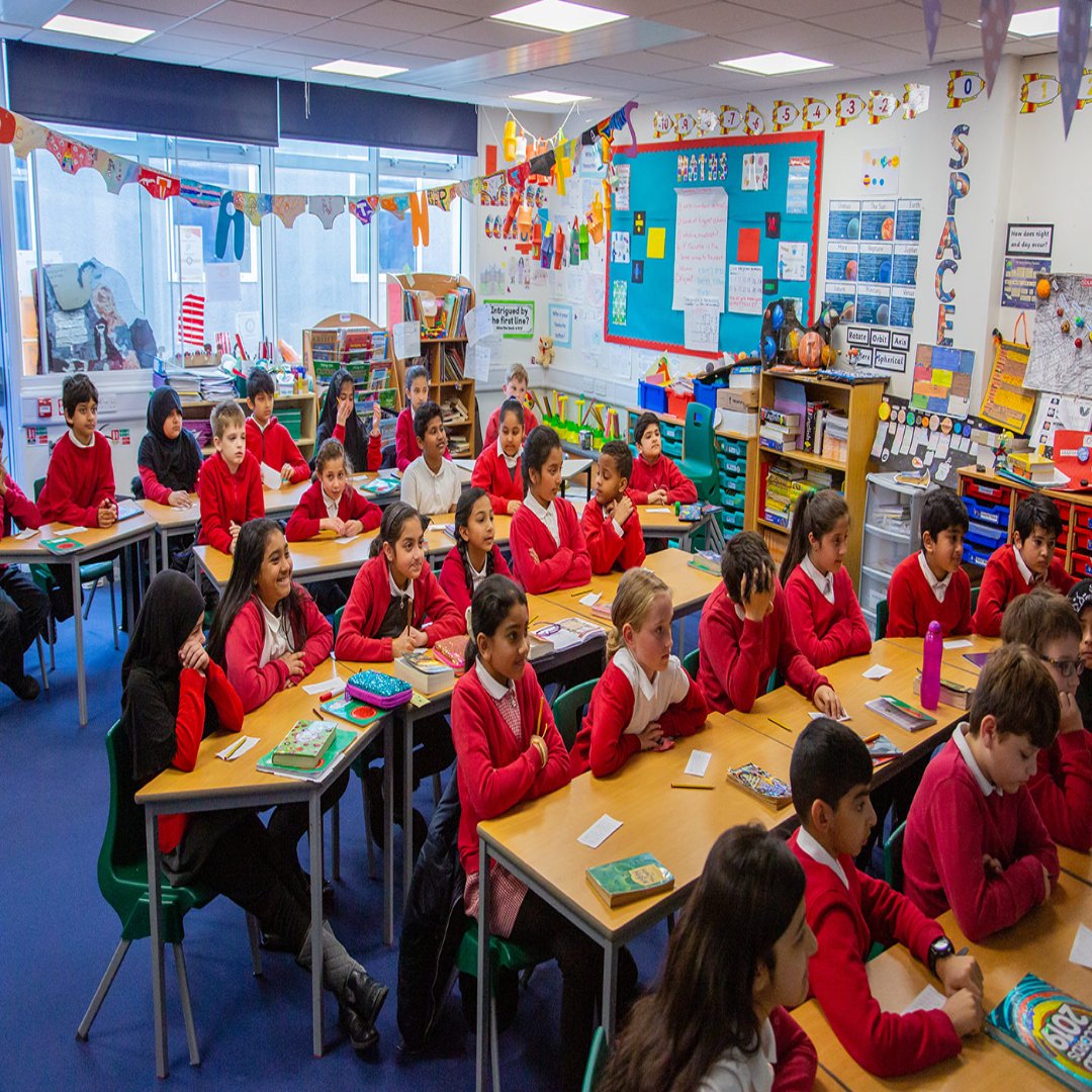 Modern school building with spacious classrooms and green playground at De'Saint Public School campus